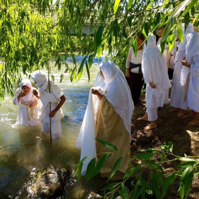 Mandaean women and men participate in a river ritual.